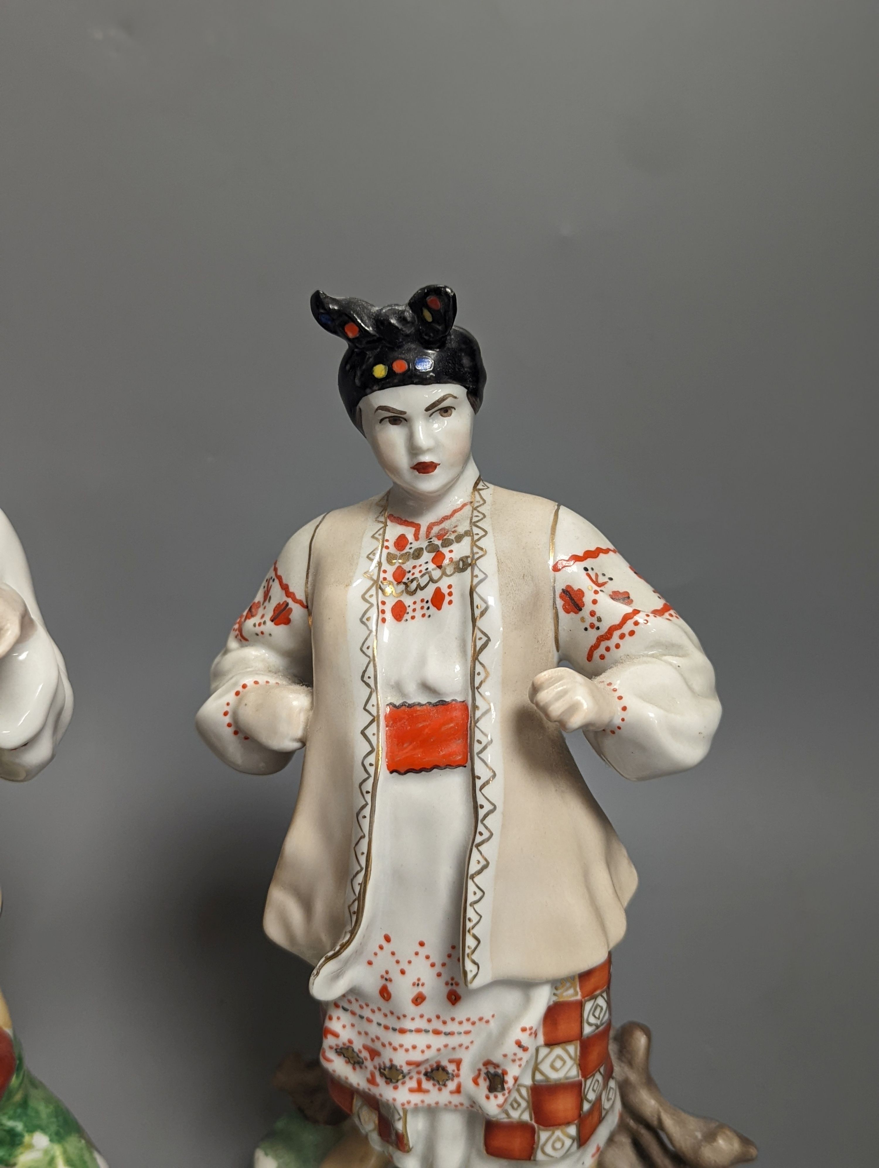 A pair of Russian porcelain figures of a Cossack and his wife 25cm